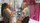 Amrit standing and speaking with an older man, in front of a wall of canes.