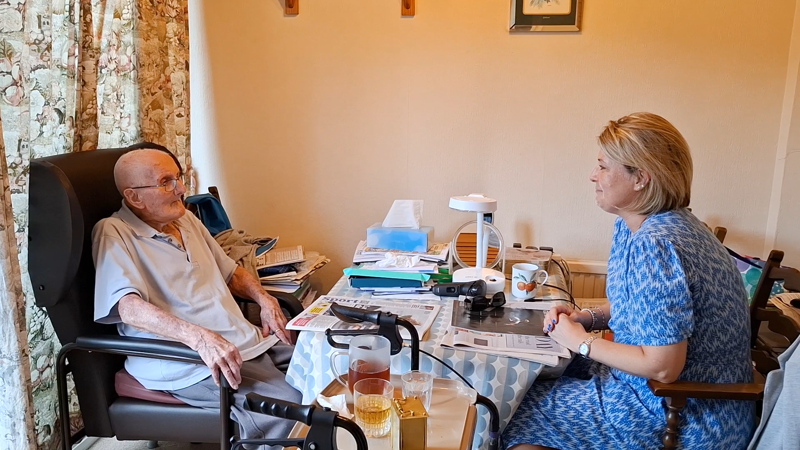 Claire and George enjoying a conversation sat at his kitchen table.